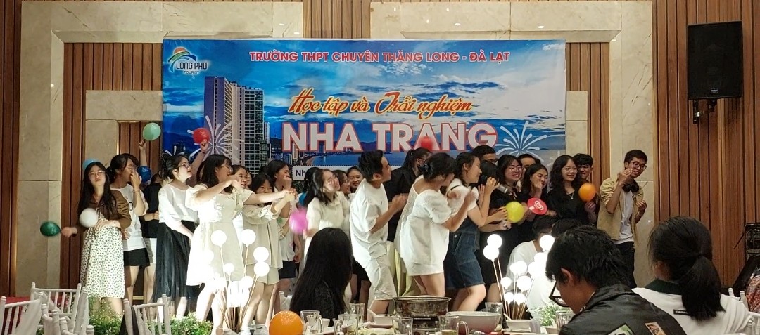 A group of people dancing in front of a banner Description automatically generated