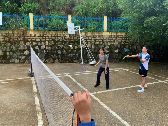 A group of people playing badminton Description automatically generated