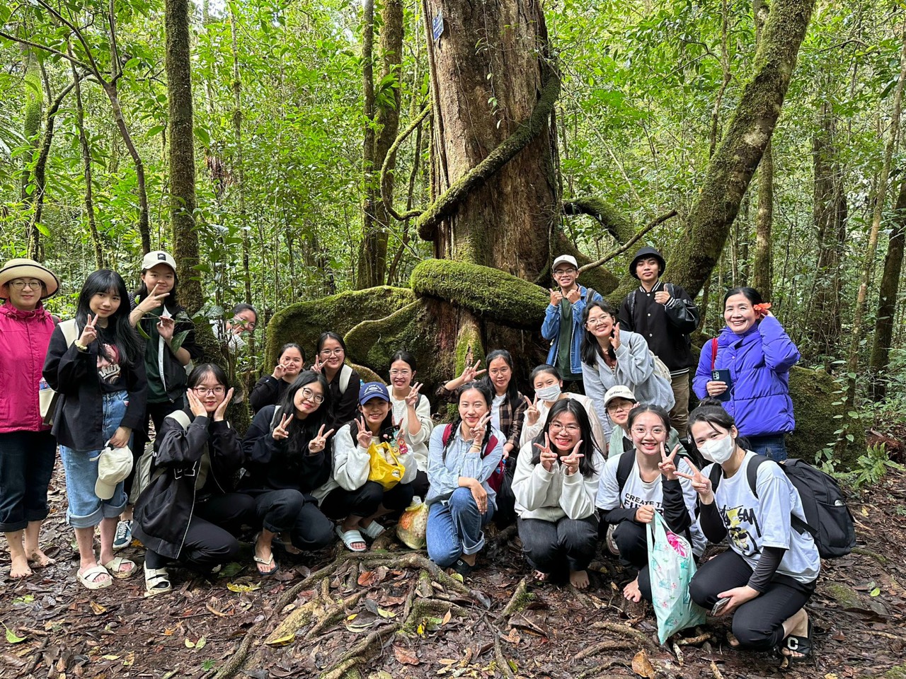 A group of people posing for a photo in the woodsDescription automatically generated