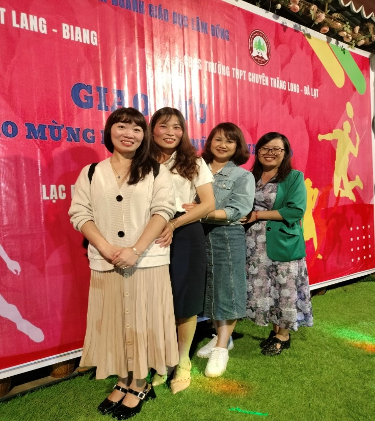 A group of women standing in front of a banner Description automatically generated
